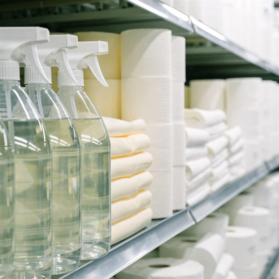 Household aisle shelf with plain spray bottles and paper goods